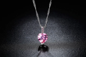 Detail eines rosa herzförmigen Edelstein-Anhängers an einer Silberkette mit Zirkon