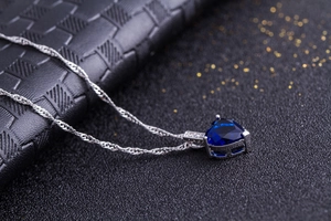 Makroaufnahme der herzförmigen blauen Edelsteinkette mit Silberkette auf Leder