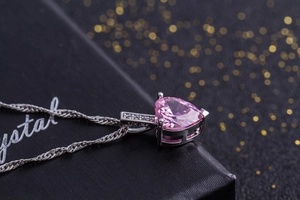 Makroaufnahme des herzförmigen rosa Zirkon-Anhängers mit Silberkette und 10K GF Stempel