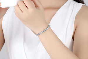 Detailansicht eines silbernen Tennisarmbands mit Zirkonia-Steinen am Handgelenk