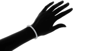 Detailansicht eines Tennisarmbands mit Zirkonia auf einer schwarzen Handsilhouette