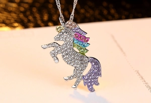 Détail d'un pendentif licorne avec cristaux colorés sur un collier en argent