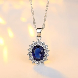 Elegant silver necklace featuring oval blue sapphire pendant with halo zircon accents