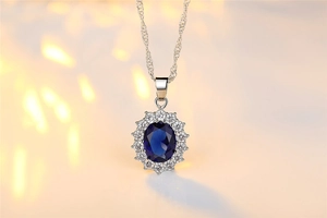 Macro detail of oval sapphire pendant with sparkling zircon halo on a silver rope chain