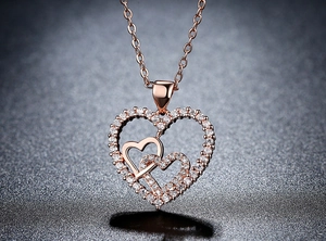Macro shot of rose gold double heart necklace pendant set with sparkling white zircon
