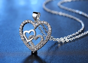 Macro shot of triple interlocking heart pendant necklace featuring shimmering cubic zirconia