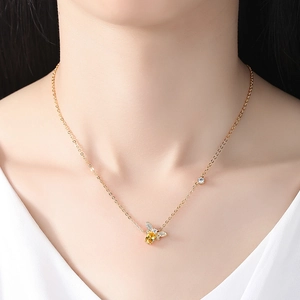 Collier abeille doré avec pierre jaune et pavé de zircons porté par un mannequin