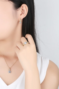 Nahaufnahme eines Schmucksets mit goldener Zirkonia Halskette und Ohrringen am Model