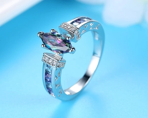 Macro view of marquise cut colorful zircon ring with hollow pavé setting and blue side stones