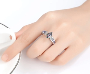 Close-up of a woman wearing a marquise-cut colorful zircon ring with silver finish