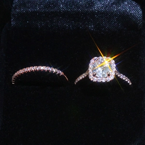Dettaglio del set di anelli in oro rosa con pietra taglio cushion e fasce pavé