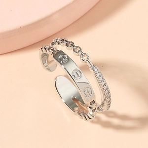 Macro detail of silver double-layered ring featuring chain link and screw motif engraving