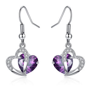 Macro shot of heart-shaped purple crystals in silver earrings with zircon accents