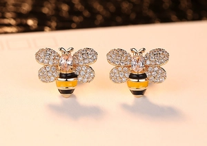Gros plan de boucles d'oreilles abeille avec zircons blancs et émail jaune noir