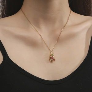 Detailed close-up of a Christmas tree pendant with colorful zircon stones on a gold chain