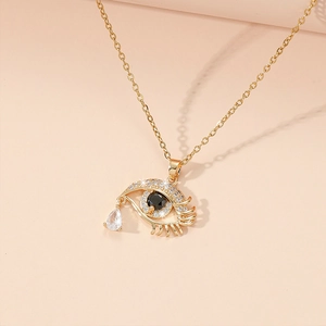 Détail du pendentif œil maléfique doré avec zircons brillants et gemme en goutte d'eau