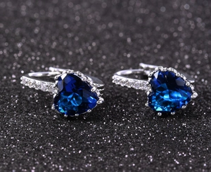 Close-up of heart-shaped blue zircon earrings with sparkling pavé cubic zirconia