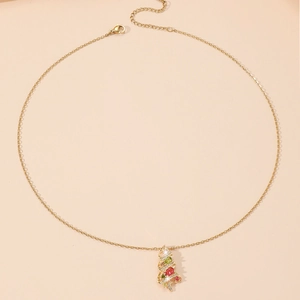 Close-up of golden Christmas tree pendant necklace with colorful zircon stones on fine chain