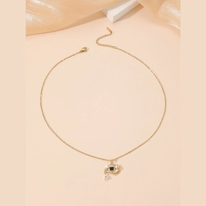 Collier doré œil protecteur avec pierre noire et pendentif en zircone sur fond beige
