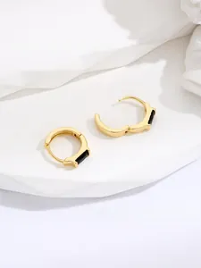 Detailed macro view of square black gemstone hoop earrings with polished gold finish