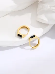 Close-up of gold-plated hoop earrings featuring elegant rectangular black gemstones
