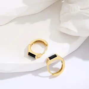 Minimalist gold hoop earrings featuring a square black gemstone on a white stone base
