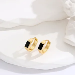 Elegant gold square hoop earrings with black rectangular gemstone on white pedestal