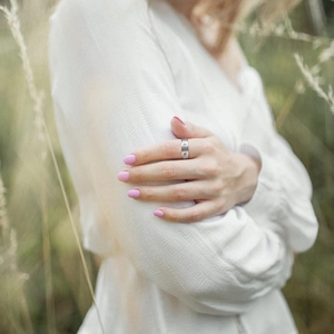 Polished silver stainless steel spinner ring with engraved patterns on model's hand
