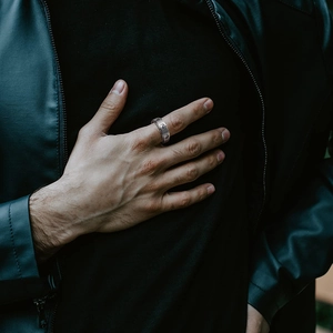 Detailed view of men's spinning Tai Chi ring in stainless steel worn on finger