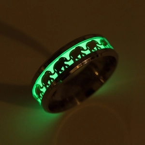 Vista macro dettagliata della fascia luminosa verde con motivi di elefanti su anello in titanio