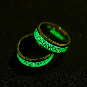 Glow-in-the-dark musical notes on green luminescent inlay of polished steel rings