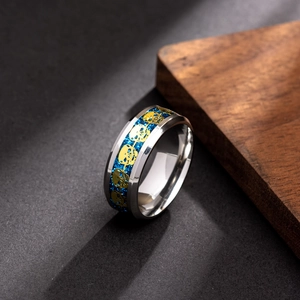 Macro shot of silver ring with blue glitter inlay and golden skull patterns