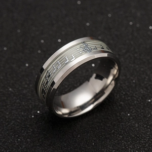 Macro shot of stainless steel music ring with luminous staff and musical notes pattern