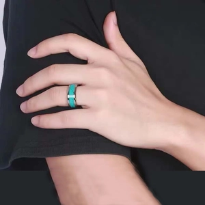 Men's titanium steel ring featuring inlaid turquoise band on finger with black background