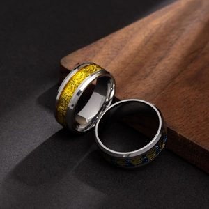 Punk style stainless steel skull rings in blue and yellow colors on wooden background