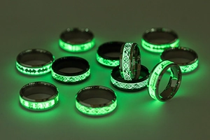 Macro-opname van lichtgevende draakpatronen die groen oplichten op zwarte stalen ringen