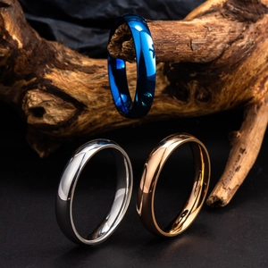 Détails de bagues polies bleu, argent et or rose sur une branche de bois décorative