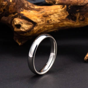 Macro d'une bague minimaliste en argent poli sur bois naturel avec reflets nets précis