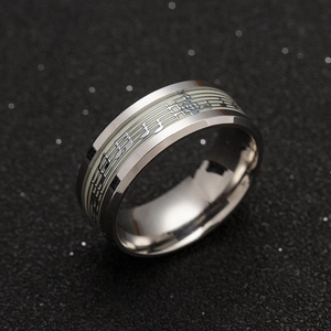 Luminous musical notes and staff pattern on wide stainless steel ring with star background