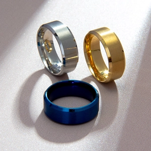 Macro detail of 8mm matte stainless steel rings in silver, gold, and blue finish