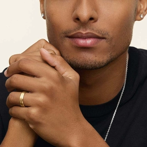 Male model wearing 8mm matte gold ring, silver chain necklace, and stud earrings