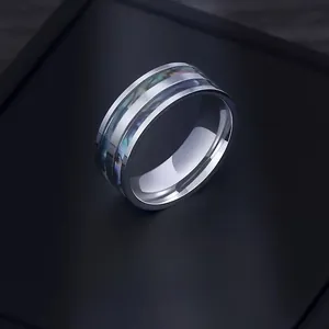 Close-up of titanium steel ring with colorful natural shell inlay and polished metal finish