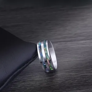Detail shot of men's titanium steel ring featuring colorful abalone shell inlay