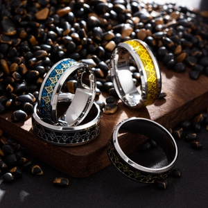 Macro detail of four men's stainless steel Freemason rings in gold, blue, silver, and black