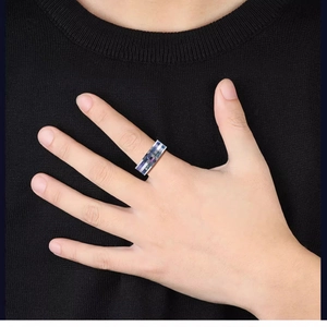 Modern titanium steel ring featuring iridescent shell inlay worn on a male model hand
