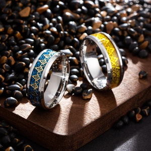 Freemason stainless steel rings with blue and gold glitter inlay on a dark wooden background