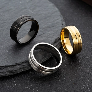 Detailed view of three-color matte titanium steel rings with parallel grooves on slate