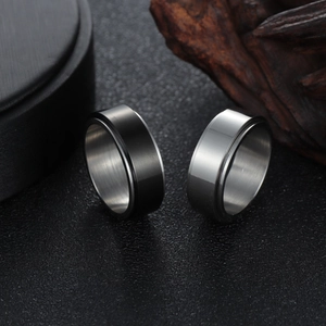 Detail of silver and black stainless steel spinner rings with brushed metal texture
