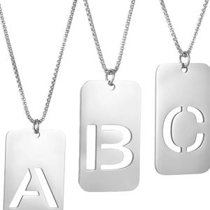 Tres collares con colgantes rectangulares de acero inoxidable sobre fondo blanco