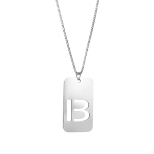Détail macro du pendentif rectangulaire argenté avec lettre B ajourée sur chaîne acier